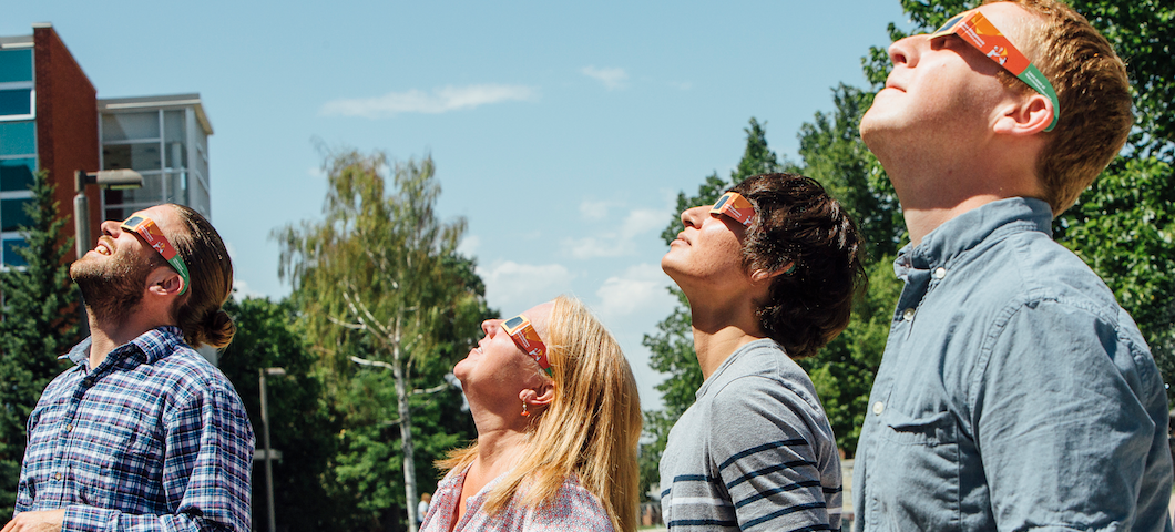 MSU students looking at the sun with protective glasses