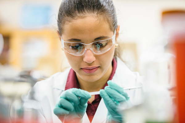 Image of female student working with biological lab equipment 