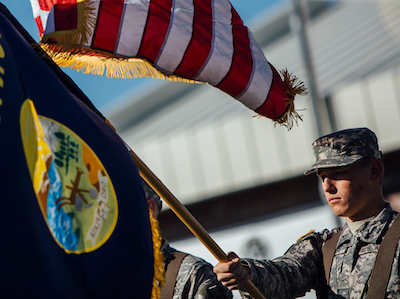 military ROTC student waving large Montana flag