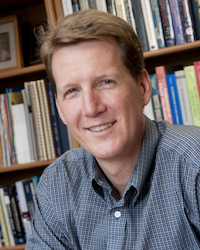 portrait photo of Jeff Heys in front of shelf of books