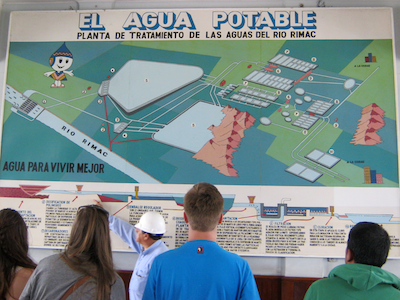 students in Peru looking at poster about water treatment