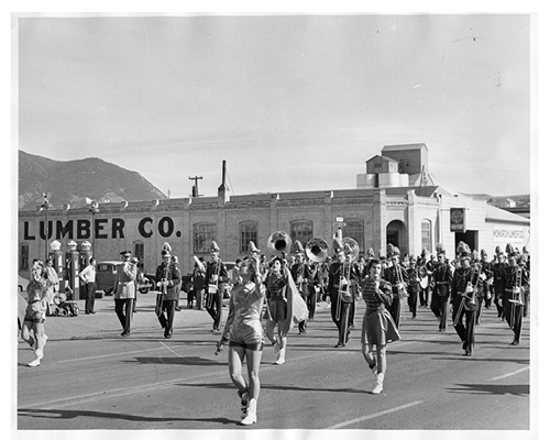 The Montana State College marching band and flag holders perform in Bozeman during a parade in the late 1950s.